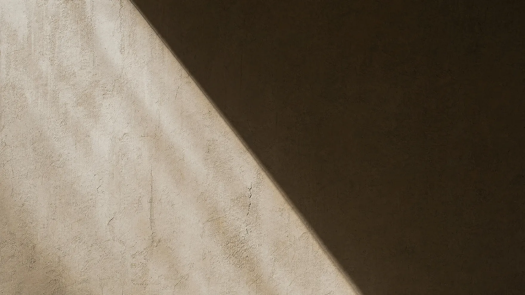 A single beam of light dividing a plain wall into two distinct halves.
